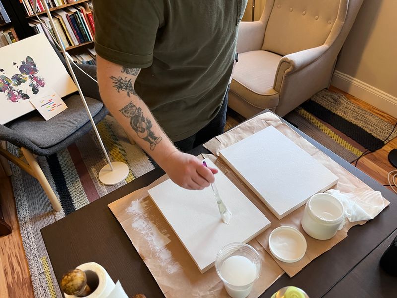 Matty applying gesso to art panels
